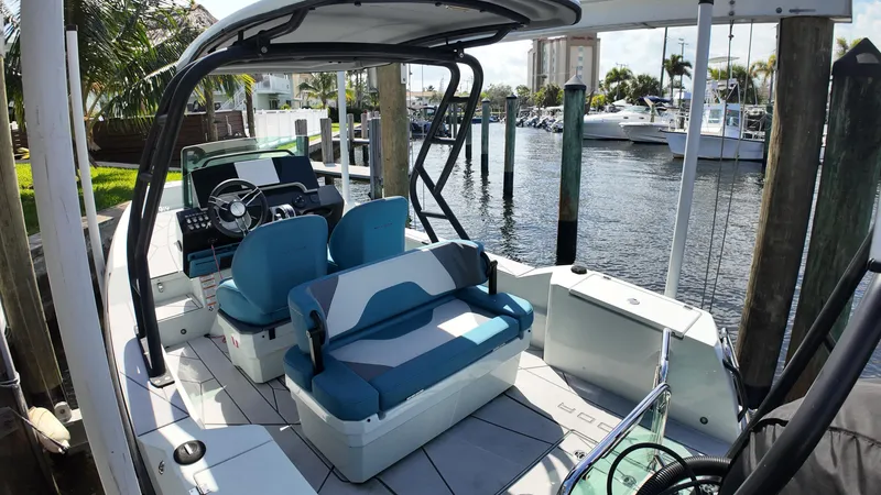 Slide: The Image of 2022 Saxdor SX200 boat interior with blue seating, docked at a marina. - 9