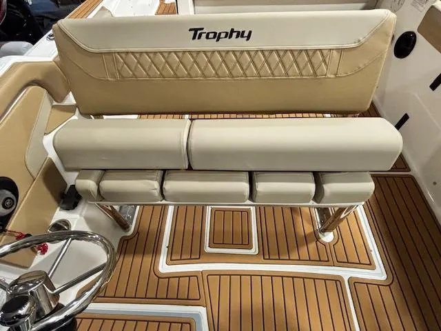 Slide: The Image of 2025 Bayliner T22 SC boat interior with tan seating and wood-patterned flooring. - 14