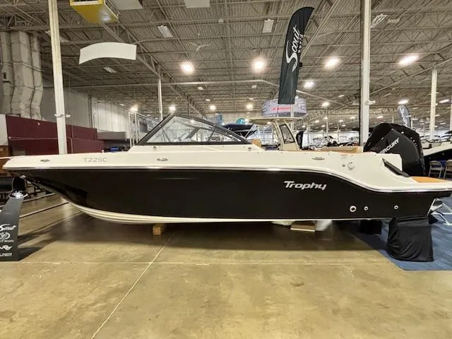 The Image of 2025 Bayliner T22 SC boat displayed indoors, featuring sleek black and white design. - 2