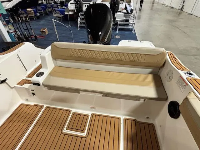 Slide: The Image of 2025 Bayliner T22 SC boat interior with tan seating and wood-patterned flooring. - 10