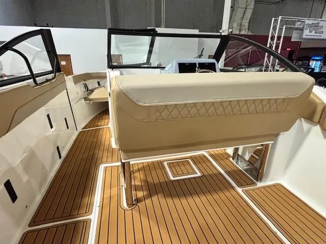 Slide: The Image of 2025 Bayliner T22 SC boat interior with tan seating and wood-style flooring. - 12