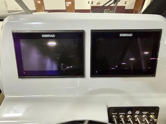 Slide: The Image of Dual Simrad displays on 2025 Bayliner T22 SC boat dashboard. - 18