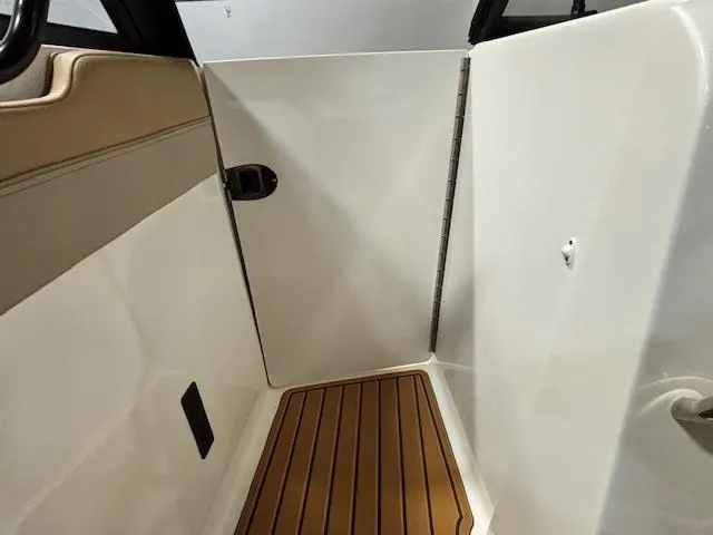 Slide: The Image of 2025 Bayliner T22 SC interior with sleek design and wood-patterned flooring. - 25