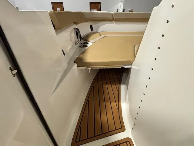 Slide: The Image of 2025 Bayliner T22 SC interior with tan seating and wood-patterned flooring. - 26