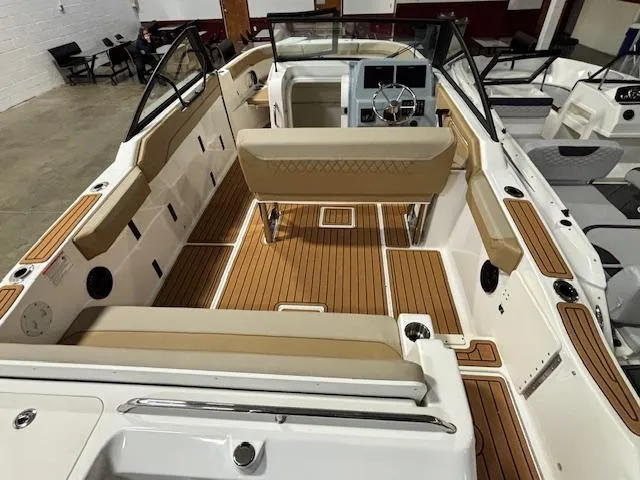 Slide: The Image of 2025 Bayliner T22 SC boat interior with tan seating and wood-style flooring. - 9