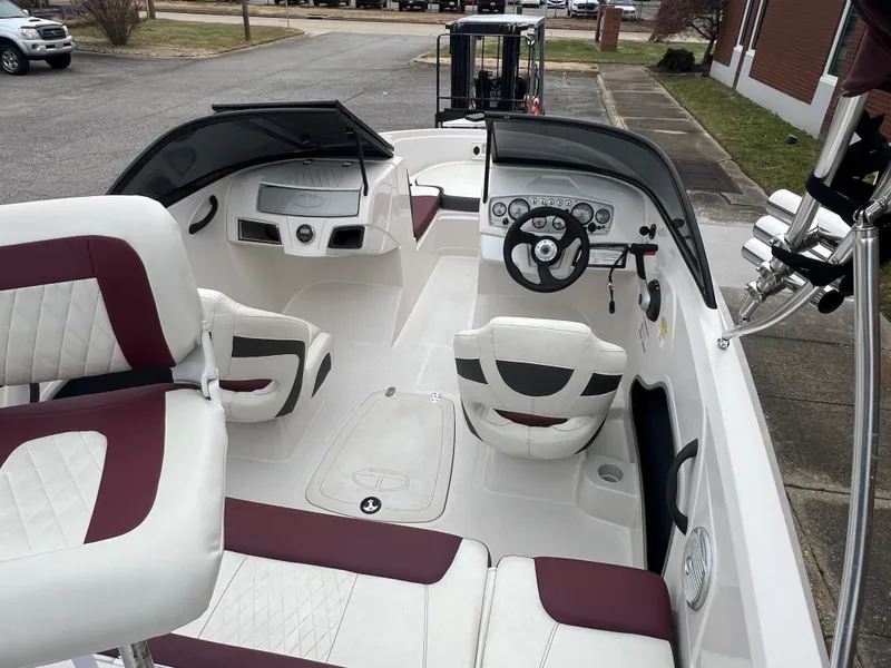 Slide: The Image of 2016 Tahoe 450 TF boat interior with white and maroon seating, steering wheel, and dashboard. - 11