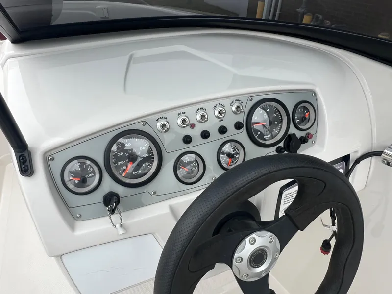 Slide: The Image of Dashboard of a 2016 Tahoe 450 TF boat with gauges and steering wheel. - 19