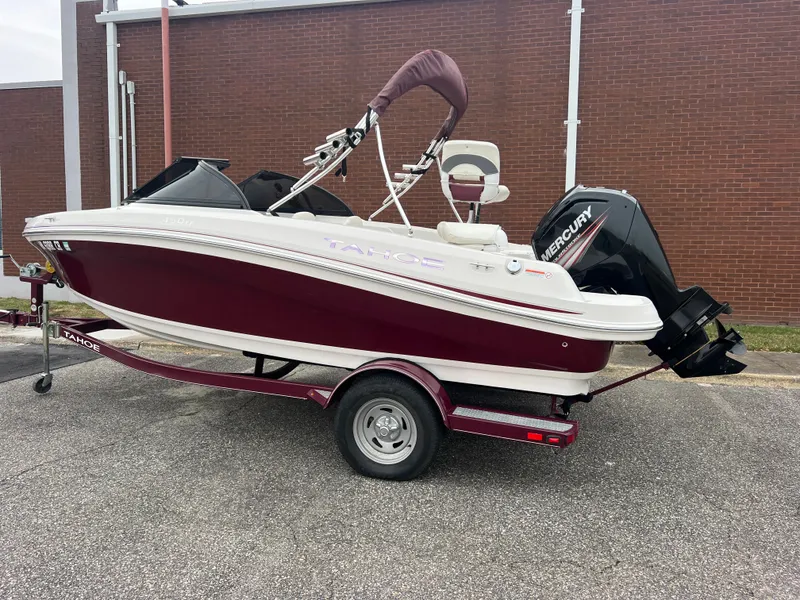 Slide: The Image of 2016 Tahoe 450 TF boat with Mercury engine on trailer, parked outdoors. - 2