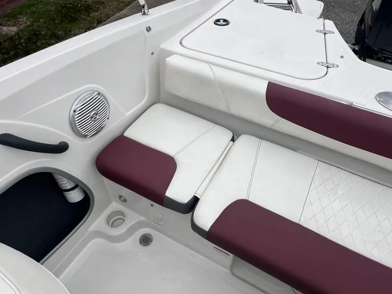 Slide: The Image of 2016 Tahoe 450 TF boat interior with white and maroon seating, speaker, and storage compartment. - 22