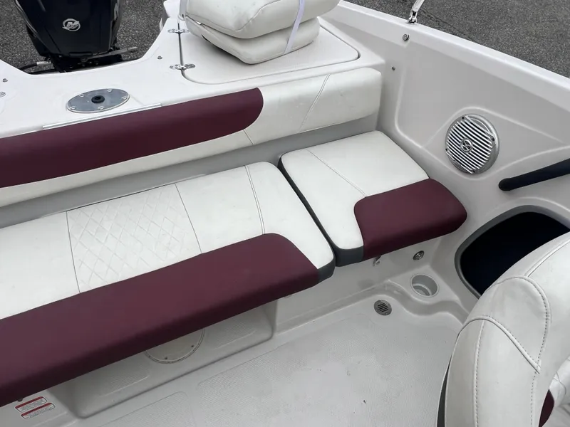 Slide: The Image of 2016 Tahoe 450 TF boat interior with white and maroon seating, speaker, and storage compartment. - 23