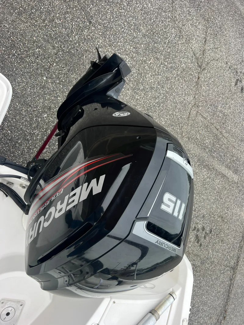 Slide: The Image of Mercury 115 outboard motor on 2016 Tahoe 450 TF boat, parked on asphalt. - 27