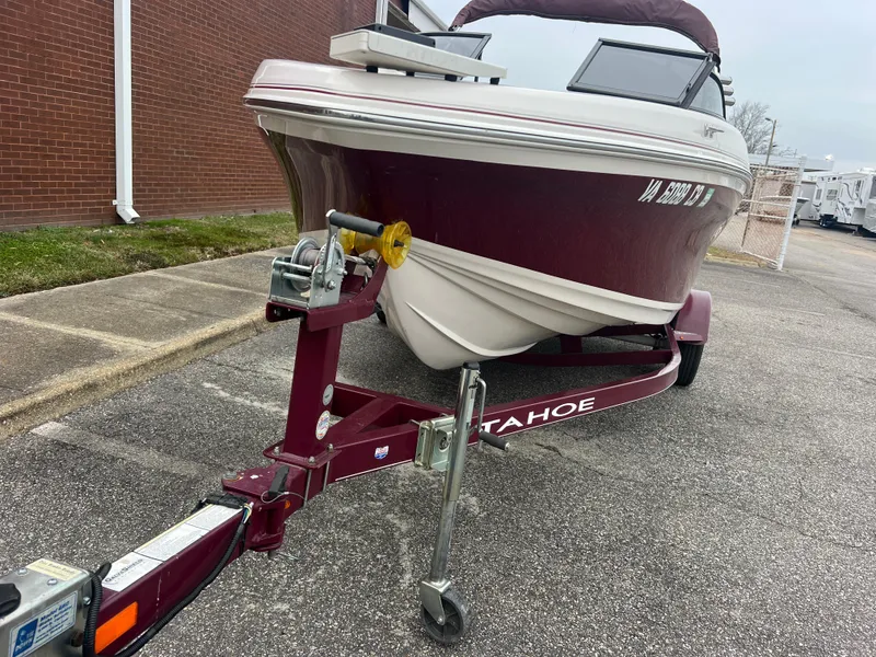 Slide: The Image of 2016 Tahoe 450 TF boat on trailer, parked outdoors. - 3