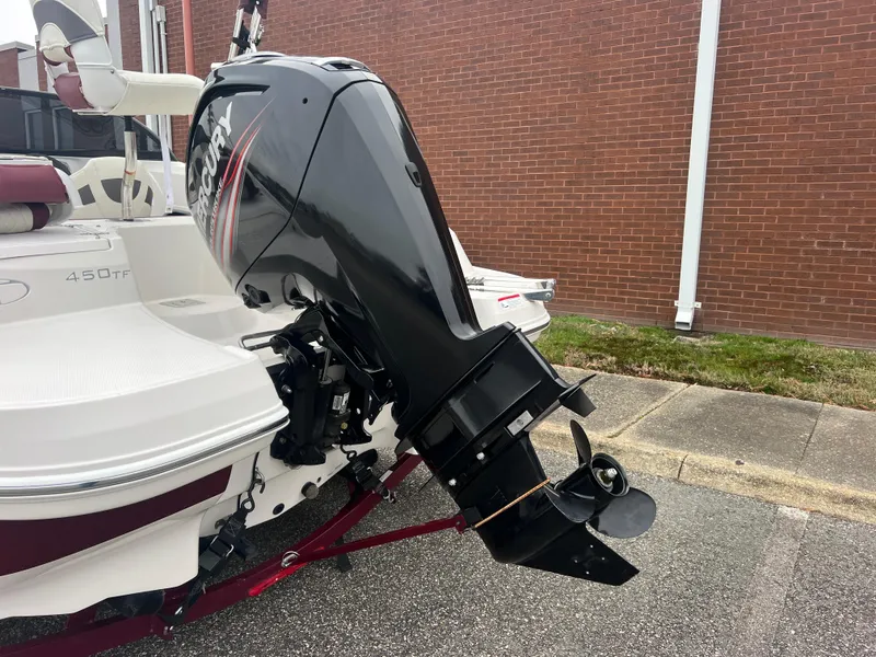 Slide: The Image of 2016 Tahoe 450 TF boat with outboard motor, parked on pavement. - 4