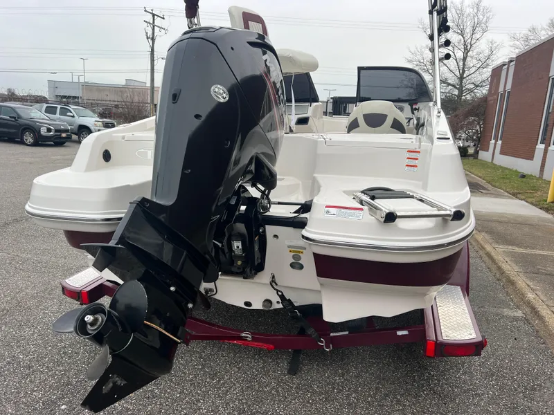 Slide: The Image of 2016 Tahoe 450 TF boat with outboard motor, parked on a trailer in a lot. - 6