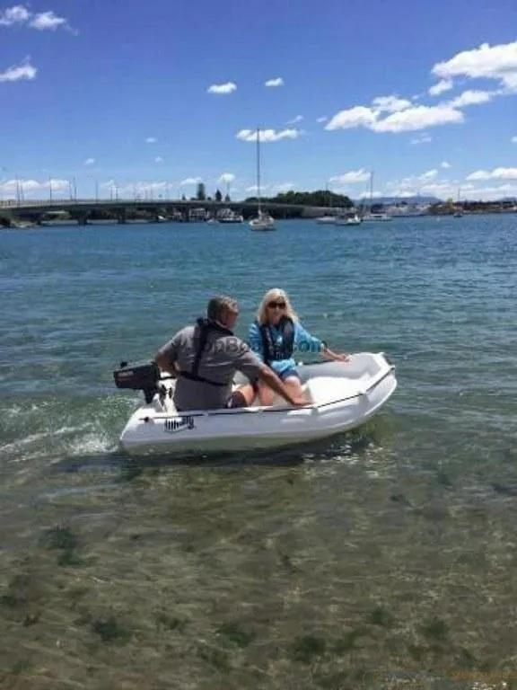 Slide: The Image of Two people in a 2022 Whaly 210 boat on a sunny day. - 3