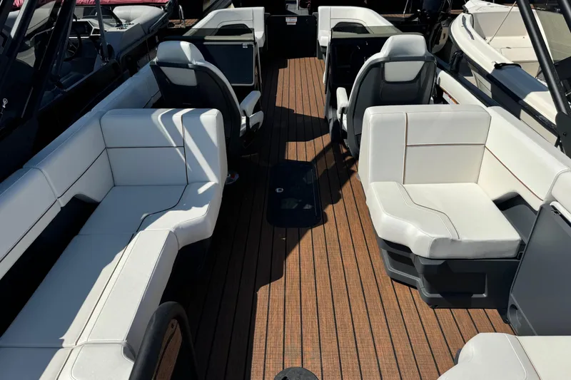 Slide: The Image of 2025 Manitou 26' Explore Navigator interior with white seating and wood flooring. - 3