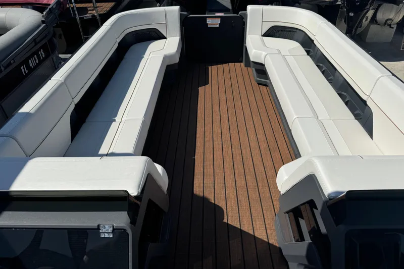 Slide: The Image of 2025 Manitou 26' Explore Navigator boat interior with spacious seating and wooden deck. - 4