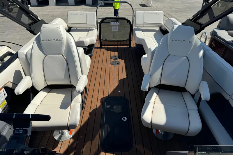Slide: The Image of 2025 Manitou 26' Explore Navigator boat interior with white seating and wood flooring. - 5