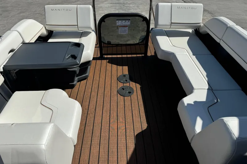 Slide: The Image of 2025 Manitou 26' Explore Navigator interior with white seating and wooden deck. - 7
