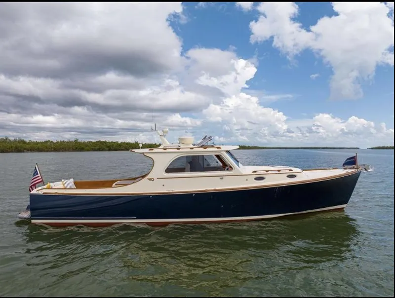 Slide: The Image of 2002 Hinckley Picnic Boat EP on calm water under cloudy sky. - 1