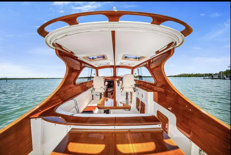 Slide: The Image of 2002 Hinckley Picnic Boat EP with elegant wooden interior on a serene water backdrop. - 10