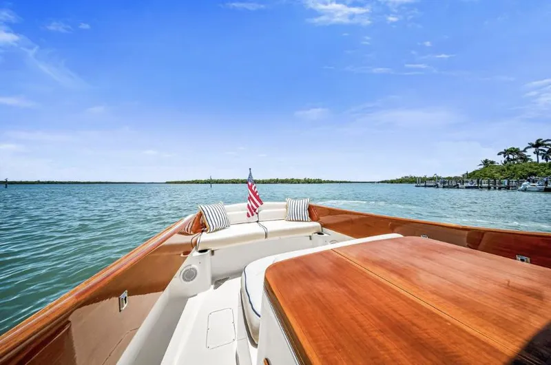 Slide: The Image of 2002 Hinckley Picnic Boat EP cruising on serene waters under a clear blue sky. - 11
