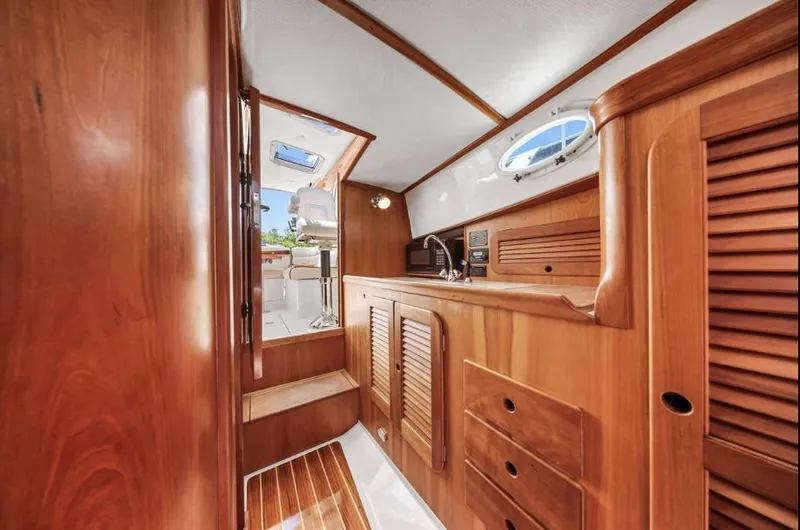 Slide: The Image of Interior of 2002 Hinckley Picnic Boat EP with wooden cabinetry and compact design. - 13