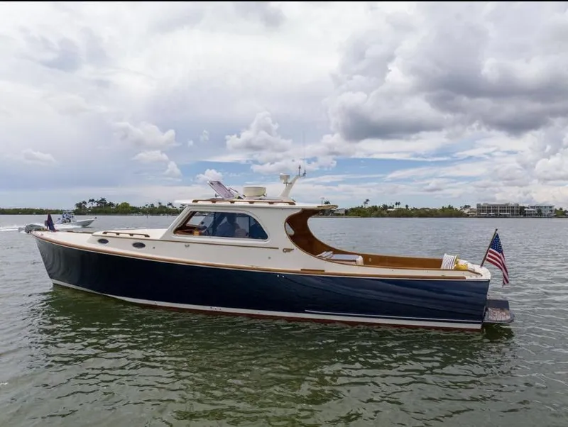 Slide: The Image of 2002 Hinckley Picnic Boat EP on calm water under cloudy sky. - 4