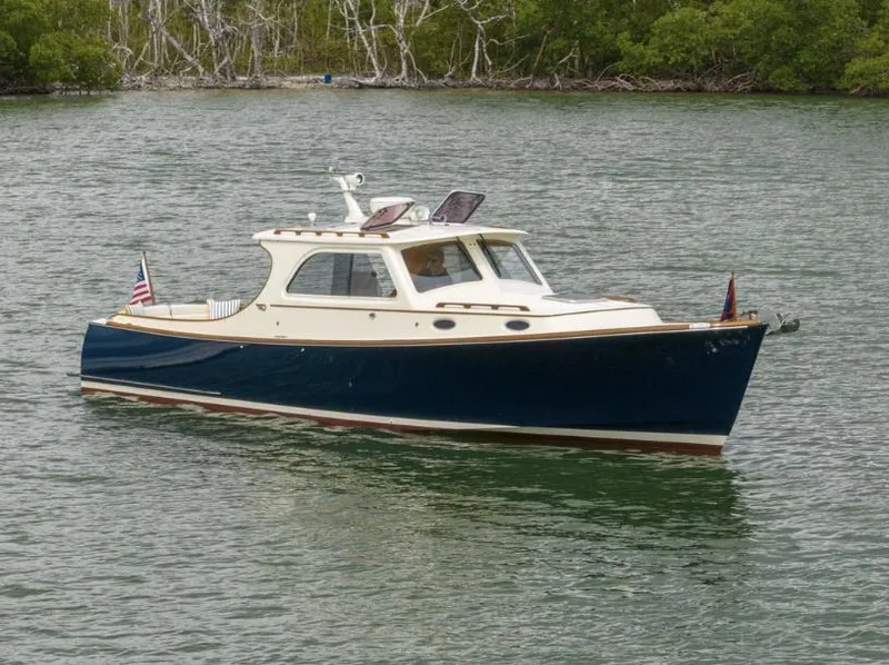Slide: The Image of 2002 Hinckley Picnic Boat EP cruising on calm waters near lush greenery. - 5