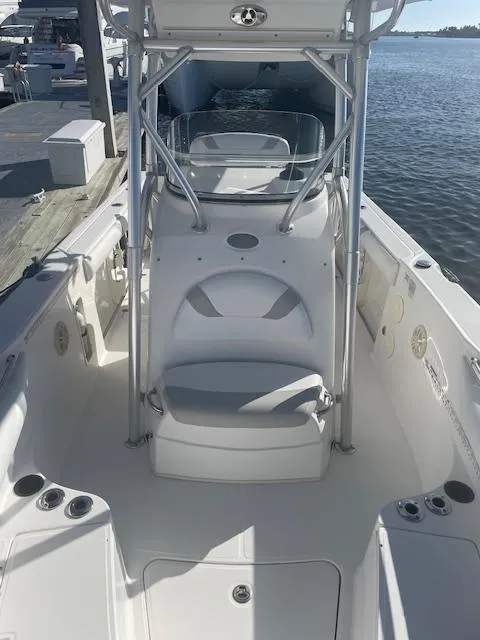 Slide: The Image of 2008 Boston Whaler 270 Outrage boat interior, featuring seating and console, docked by the water. - 14