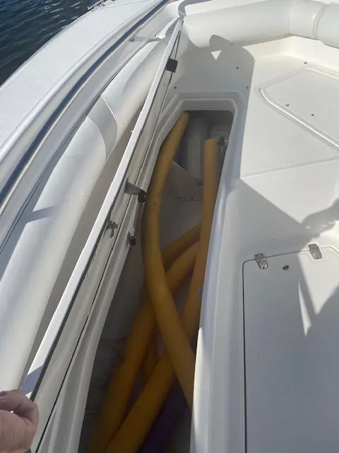 Slide: The Image of 2008 Boston Whaler 270 Outrage boat storage compartment with yellow hoses. - 19