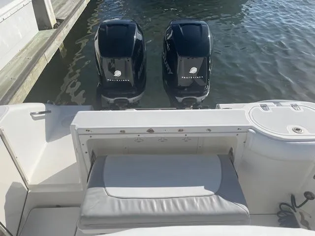 Slide: The Image of 2008 Boston Whaler 270 Outrage with twin outboard motors, docked on calm water. - 5