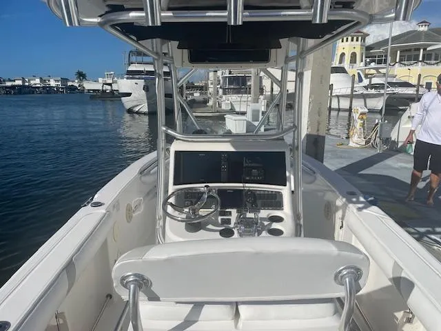 Slide: The Image of 2008 Boston Whaler 270 Outrage boat at dock, featuring helm and waterfront view. - 6