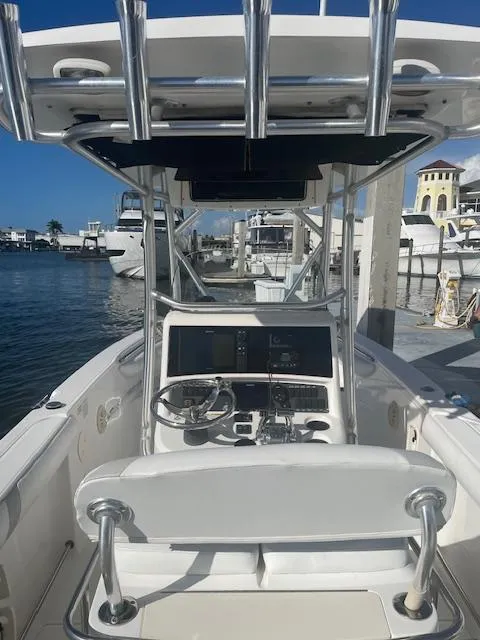 Slide: The Image of 2008 Boston Whaler 270 Outrage boat at marina, featuring helm and seating area. - 9