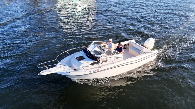 The Image of 1996 Grady-White Voyager boat cruising on open water, two people aboard. - 1