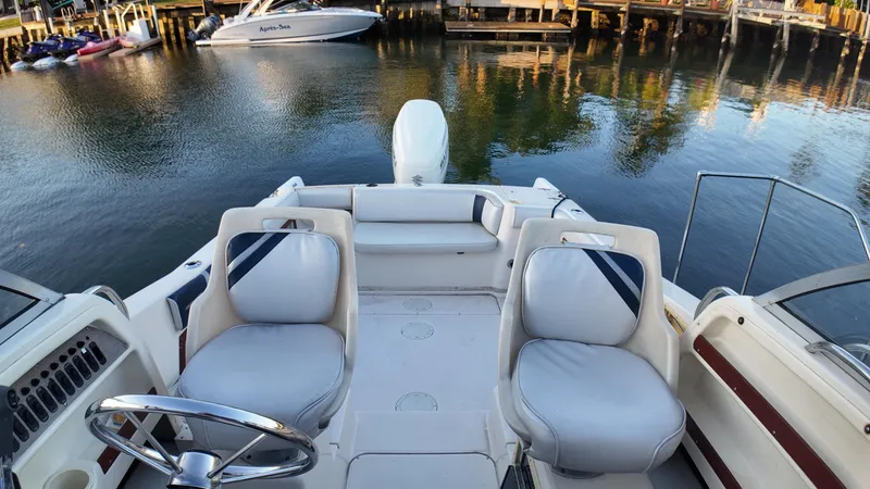 Slide: The Image of 1996 Grady-White Voyager boat interior with seating, docked on calm water. - 10