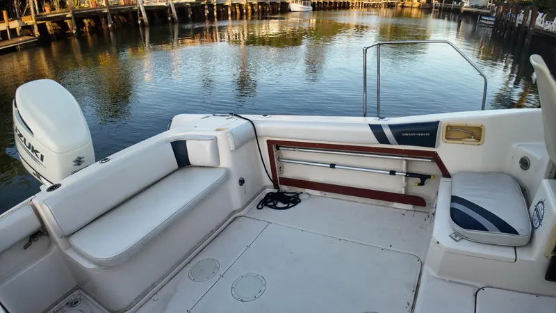Slide: The Image of 1996 Grady-White Voyager boat interior with seating, docked by calm water. - 11