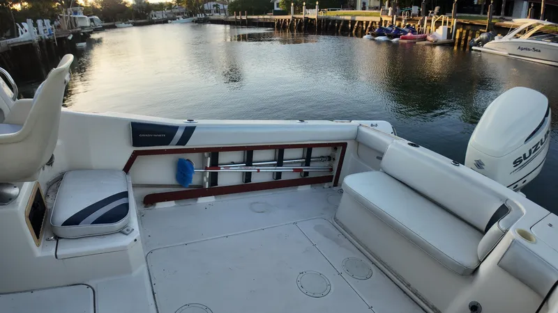 Slide: The Image of 1996 Grady-White Voyager boat interior with seating, docked by a calm waterfront. - 12