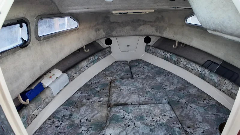 Slide: The Image of 1996 Grady-White Voyager cabin interior with cushioned seating and side windows. - 14