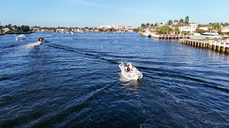Slide: The Image of A 1996 Grady-White Voyager boat cruising on a sunny waterfront with palm trees. - 20