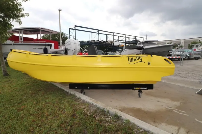 Slide: The Image of Yellow 2023 Whaly 455 R boat displayed outdoors on a trailer. - 2