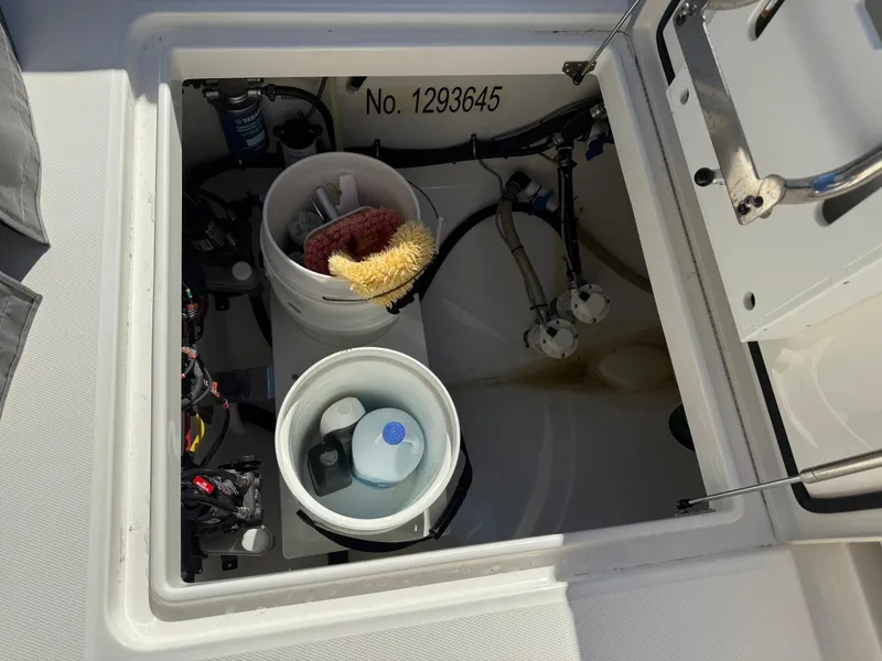 Slide: The Image of Open storage compartment on 2019 Regulator 31 boat with cleaning supplies. - 16