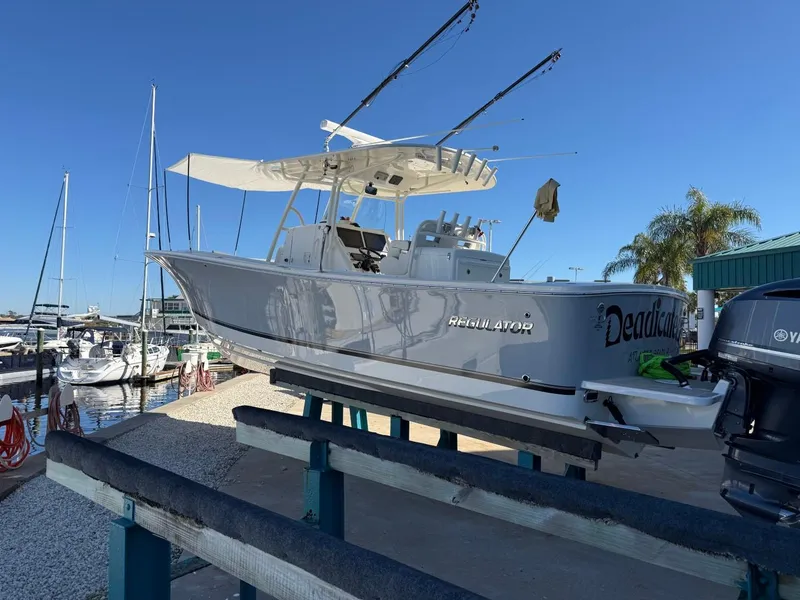 Slide: The Image of 2019 Regulator 31 boat on dock, with clear blue sky and marina background. - 3