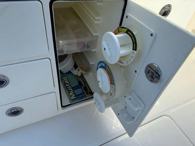 Slide: The Image of 2019 Regulator 31 boat storage with fishing line spools and tackle box. - 38