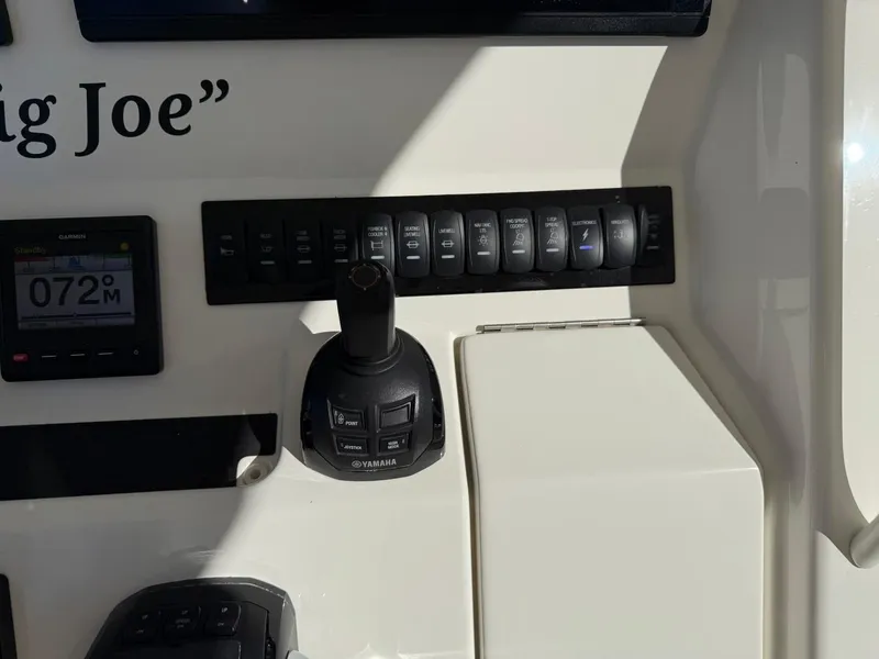 Slide: The Image of Control panel of a 2019 Regulator 31 boat with switches and joystick. - 45