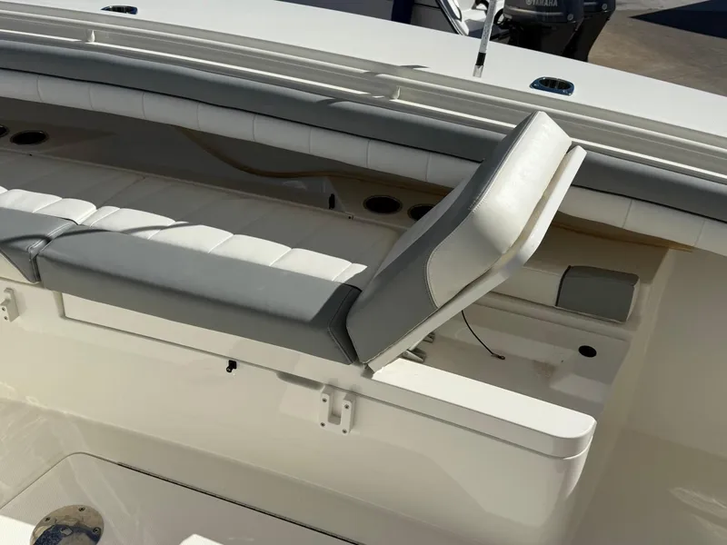 Slide: The Image of 2019 Regulator 31 boat interior with cushioned seating and storage compartment. - 49
