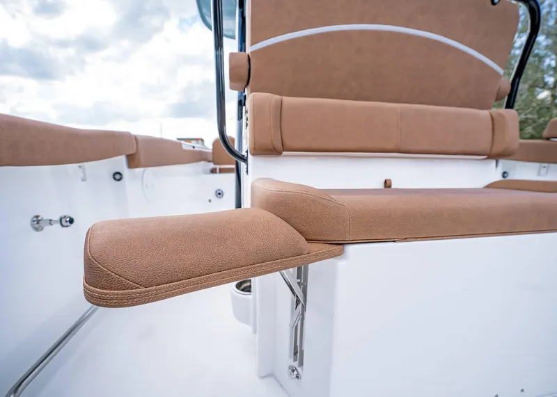 Slide: The Image of 2025 Sea Hunt Ultra 255 SE boat seating with tan upholstery and armrest detail. - 13