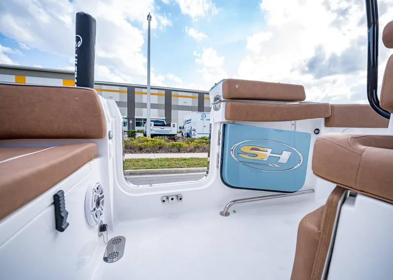 Slide: The Image of 2025 Sea Hunt Ultra 255 SE boat interior with brown seating and open side door. - 14