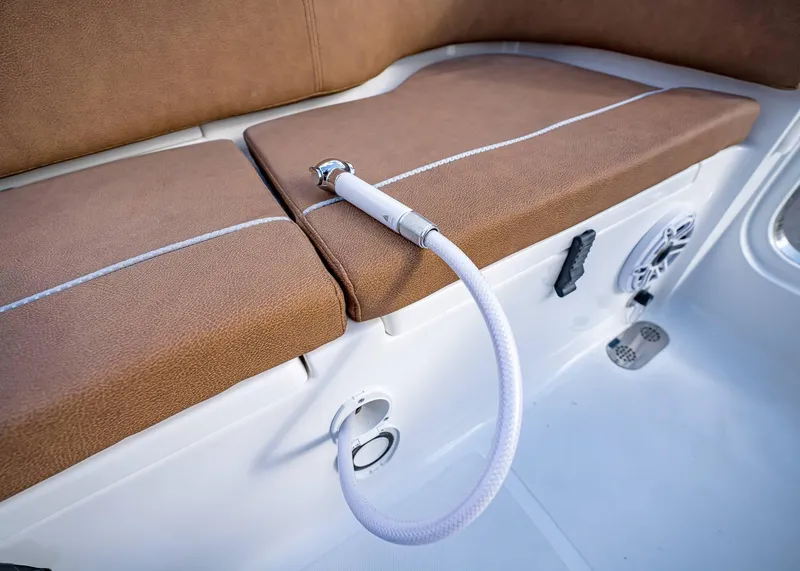 Slide: The Image of Interior of 2025 Sea Hunt Ultra 255 SE boat with brown seating and hose attachment. - 15