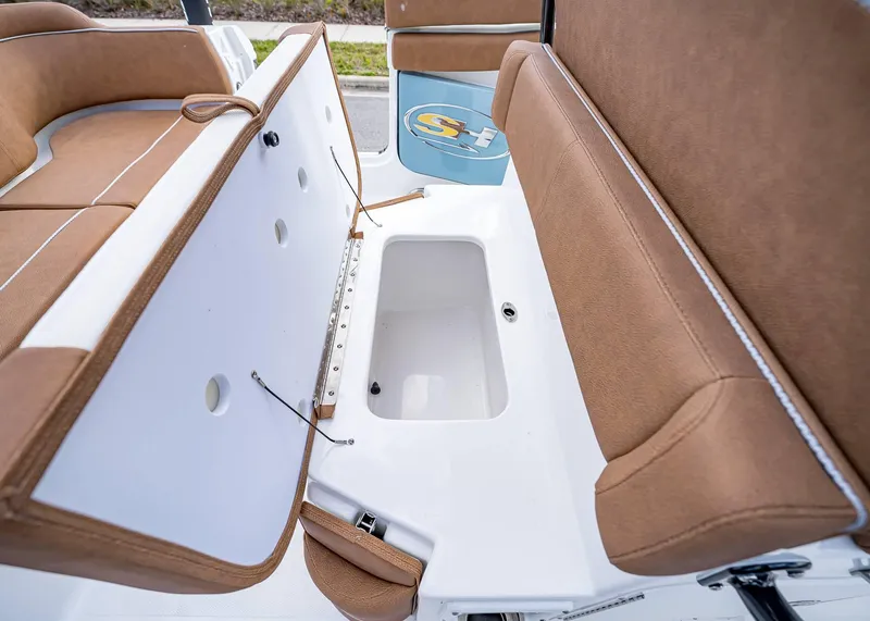 Slide: The Image of 2025 Sea Hunt Ultra 255 SE boat seating with storage compartment, featuring brown upholstery. - 16